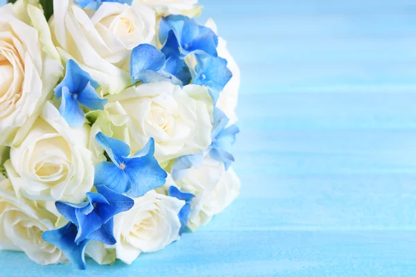 青い木製テーブルにバラで美しい結婚式のブーケ — ストック写真