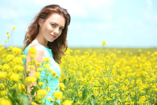 Belle jeune femme dans le champ de fleurs — Photo