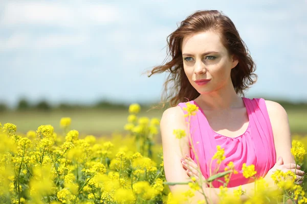 Belle jeune femme dans le champ de fleurs — Photo