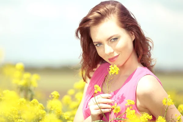 Krásná mladá žena v květu pole — Stock fotografie