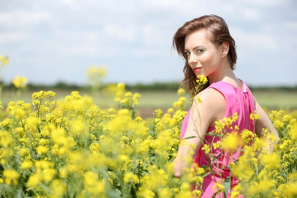 Beautiful young woman in flower field — Stock Photo, Image