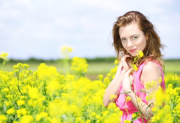 Güzel bir genç kadın çiçek alanı — Stok fotoğraf