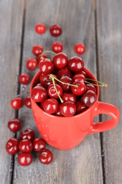 Sweet cherries in mug on wooden background — Stock Photo, Image