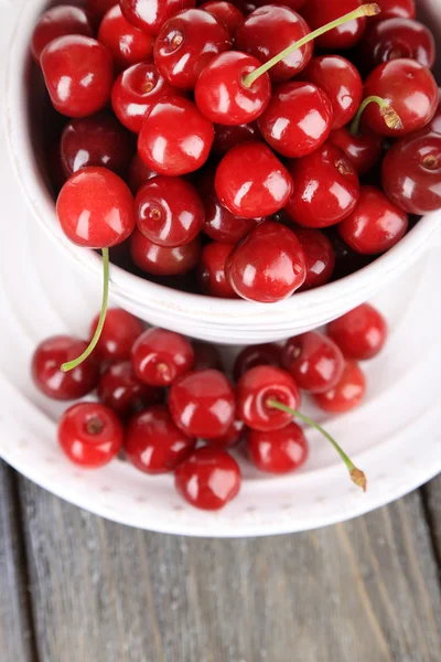 Cerezas dulces en taza sobre fondo de madera —  Fotos de Stock