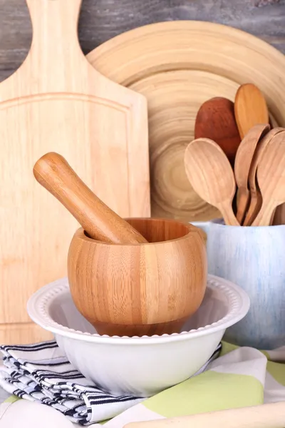 Samenstelling van houten bestek, pan, kom en snijplank op houten achtergrond — Stockfoto