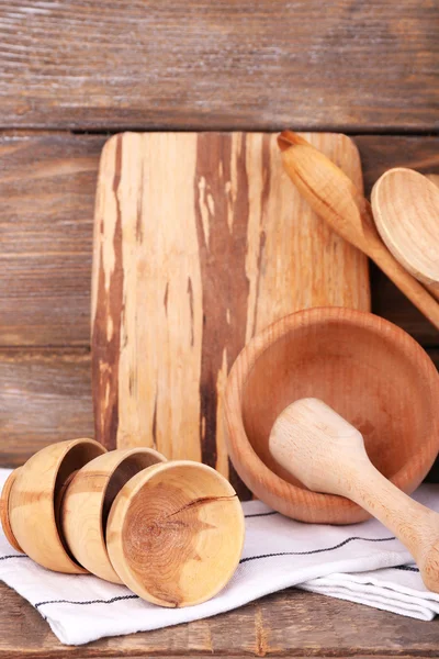 Composition of wooden cutlery, mortar, bowl and cutting board on wooden background — Stock Photo, Image