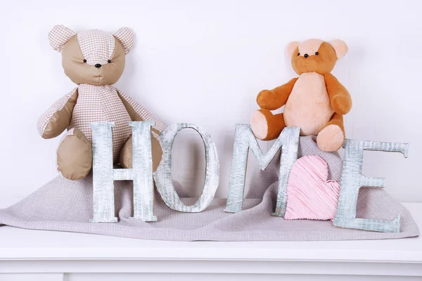 Letras decorativas formando palabra HOME con oso de peluche sobre fondo de pared —  Fotos de Stock