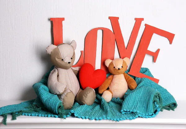 Letras decorativas formando palavra AMOR com ursinho de pelúcia no fundo da parede — Fotografia de Stock