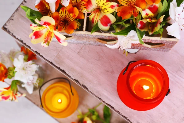 Ljusa ikon-lampor med blommor på trä stege på ljus bakgrund — Stockfoto