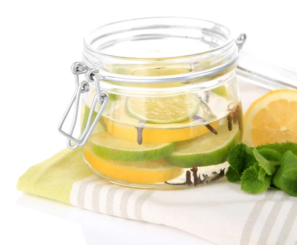 Limes sottaceto e chiodi di garofano in vaso di vetro, isolati su bianco — Foto Stock