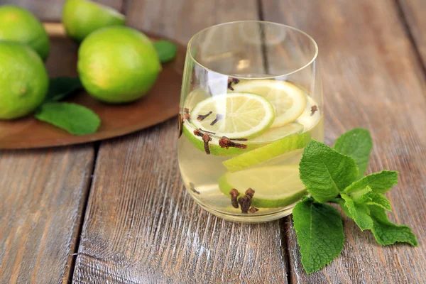 Frischen sommerlichen Drink mit Limette und Nelken in Glas, auf hölzernen Hintergrund Farbe — Stock fotografie