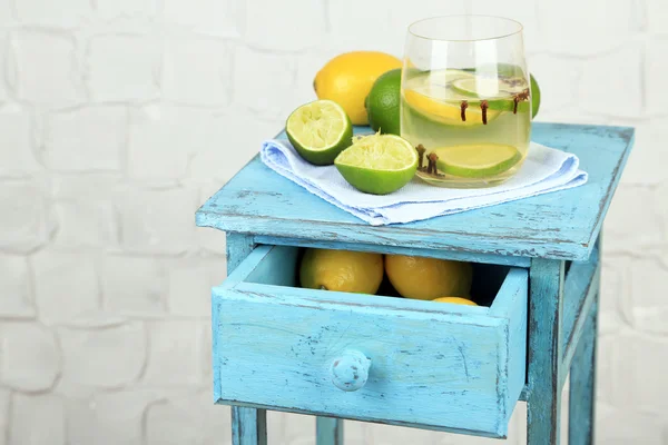 Bebida fresca de verano con cal y clavo de olor en vidrio, sobre soporte de madera de color, sobre fondo de pared claro —  Fotos de Stock