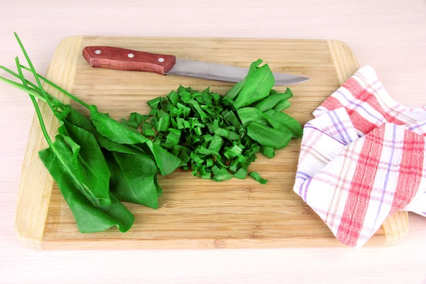 Verdes picados con cuchillo en tabla de cortar en la mesa — Foto de Stock