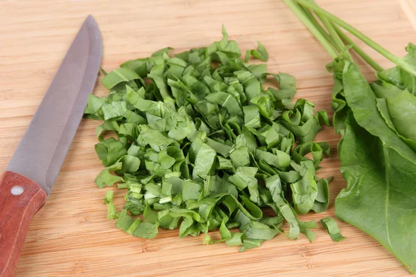 Gehacktes Grünzeug mit Messer auf Schneidebrett — Stockfoto