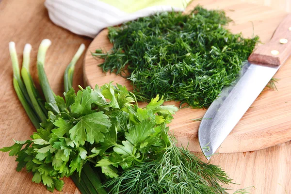 Chopped greens with knife on cutting board — Stock Photo, Image