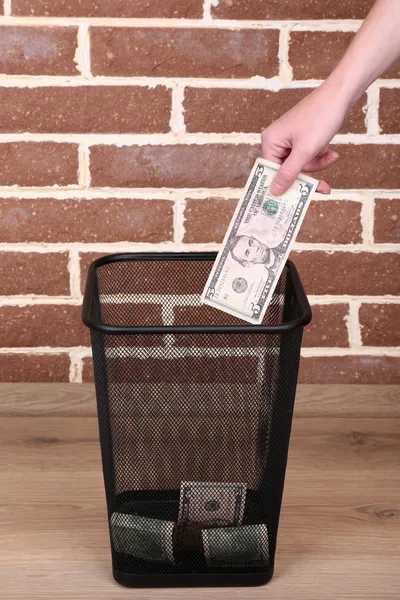 Throwing away your money on brick wall background — Stock Photo, Image