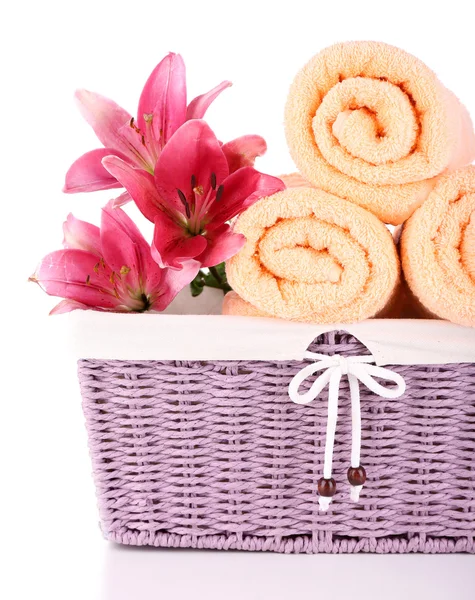 Color towels and lily flowers in wicket basket, isolated on white — Stock Photo, Image