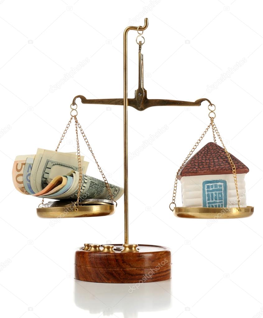 Scale with money and model of house, isolated on white