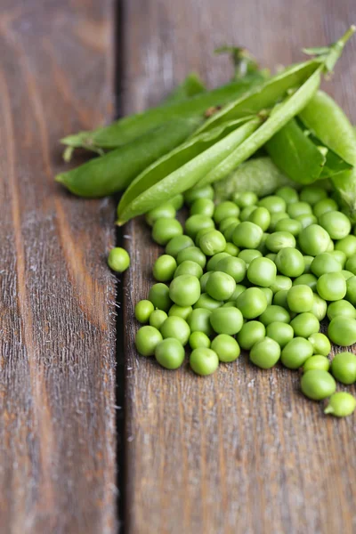 Guisantes verdes frescos sobre fondo de madera — Foto de Stock