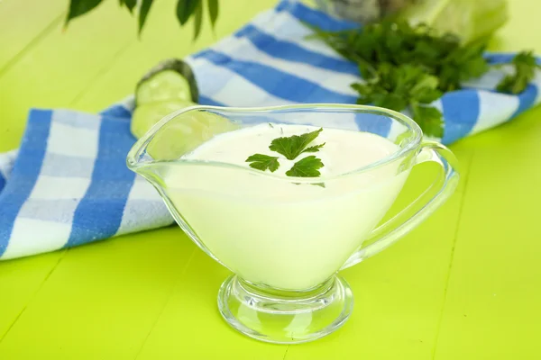 Огірковий йогурт у скляній мисці, на кольоровій серветці, на дерев'яному фоні — стокове фото