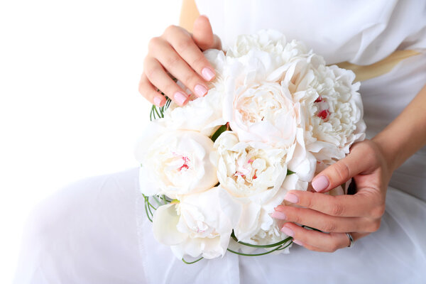 Bride holding wedding bouquet of white peonies, close-up