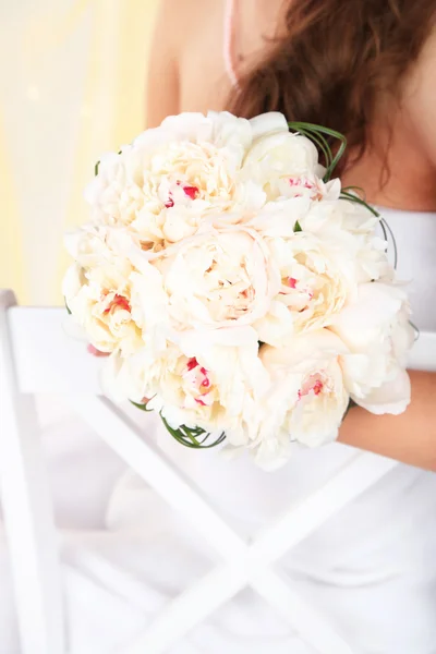 Bride holding wedding bouquet of white peonies, close-up, on light background — Stock Photo, Image