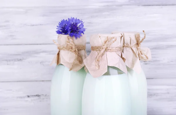 瓶牛奶和矢车菊木背景 — 图库照片
