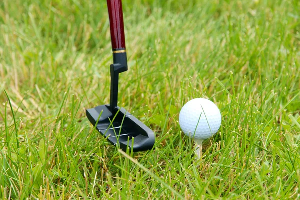 Golfbälle und Fahrer auf grünem Gras im Freien aus nächster Nähe — Stockfoto