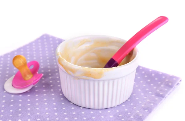 Baby bottle with milk and dirty bowl on napkin close up — Stock Photo, Image