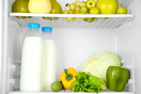 Молочные бутылки, овощи и фрукты в открытом холодильнике. Концепция потери веса . — стоковое фото
