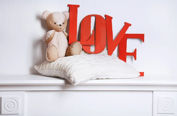 Letras decorativas formando palabra AMOR con oso de peluche sobre fondo de pared —  Fotos de Stock