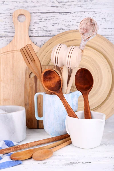 Composition of wooden cutlery, mortar, bowl and cutting board on wooden background — Stock Photo, Image