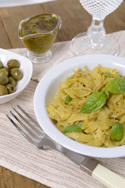 Läckra pasta med pesto på tallriken på bordet närbild — Stockfoto