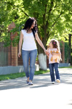 Щаслива мама і дочка. ходити в зеленому парку