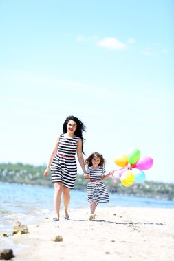 mutlu anne ve kızı. Sahilde yürüyüş