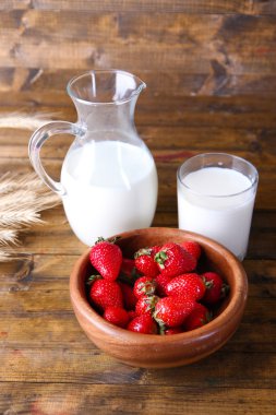 ahşap kase ve sürahi renk ahşap zemin üzerine sütlü tatlı olgun çilek