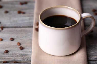 peçeteye ahşap masa arka plan üzerinde kavrulmuş kahve taneleri ve sıcak kahve Kupası