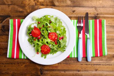 roka, domates ve susam ahşap zemin üzerinde plaka üzerinde yapılmış yeşil salata