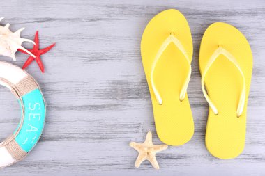 Renkli ahşap arka planda parlak parmak arası terlikler