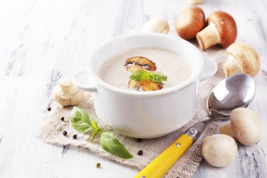 peçeteye ahşap arka plan üzerinde beyaz tencerede mantar çorbası