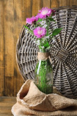 şişe ahşap zemin üzerinde parlak kır çiçekleri