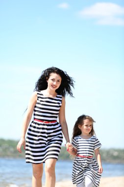 mutlu anne ve kızı. Sahilde yürüyüş
