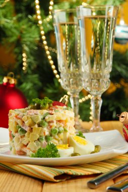 geleneksel Rus salatası olivier, üzerinde parlak zemin üzerine ahşap masa üzerinde renkli peçete