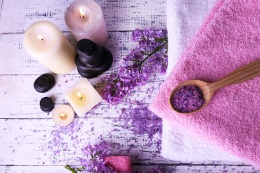 ışık arka plan üzerinde spa tedavisi, havlu ve eflatun çiçekler ile kompozisyon