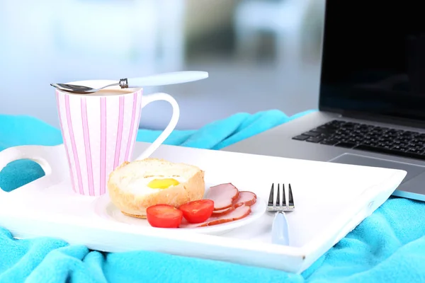 노트북 및 나무 쟁반에 맛 있는 아침 식사 구성 밝은 배경에 근접 — 스톡 사진