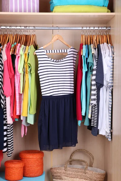 Färgglada kläder hängande i garderoben — Stockfoto