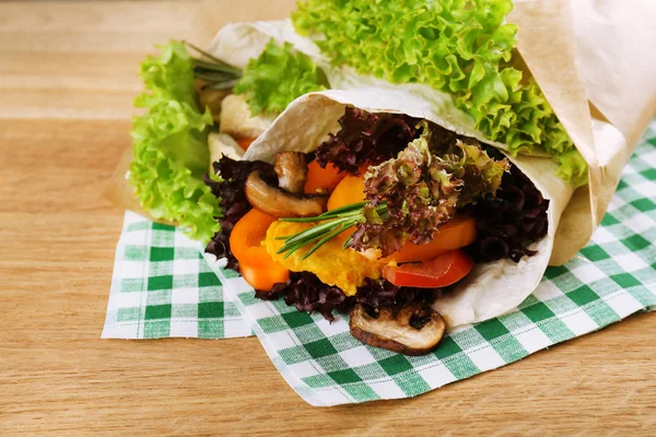 Envoltura vegetal llena de pollo y verduras frescas en la mesa de madera, de cerca —  Fotos de Stock