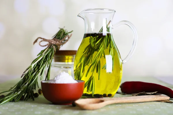 Essential Oil with rosemary in glass jug, on light background — Stock Photo, Image