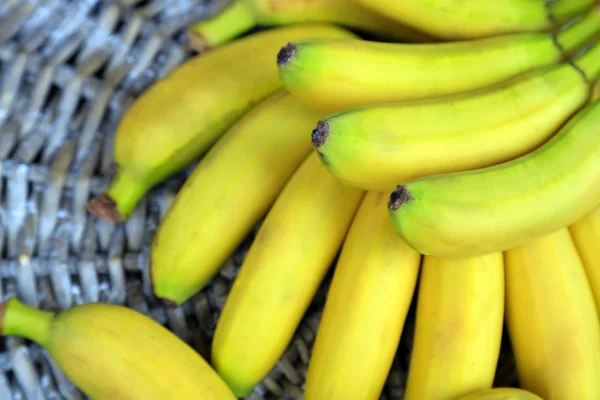 Bando de mini bananas no fundo esteira de vime — Fotografia de Stock