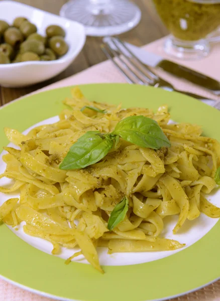 Massa deliciosa com pesto no prato na mesa close-up — Fotografia de Stock